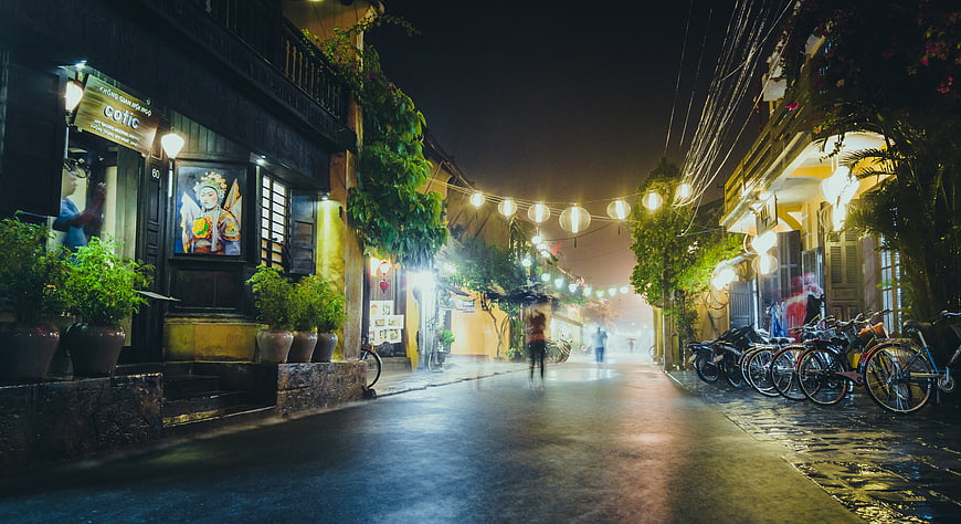 Rainy Night Street in Hoi An with Lanterns and Bicycles