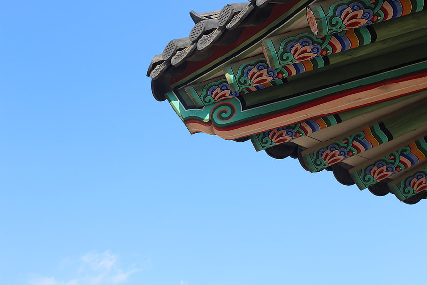 Traditional Korean Palace Roof Detail Against Blue Sky