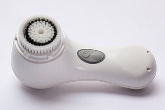 White Electric Facial Cleansing Brush with Bristle Head on White Background