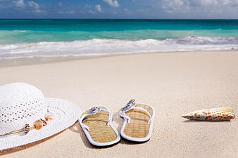 White Hat and Flip-Flops on Tropical Beach Sand