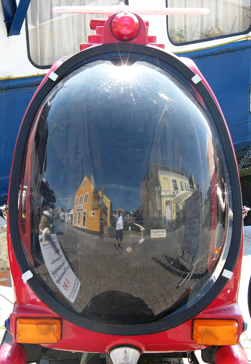 Reflection in red vehicle windshield at fair