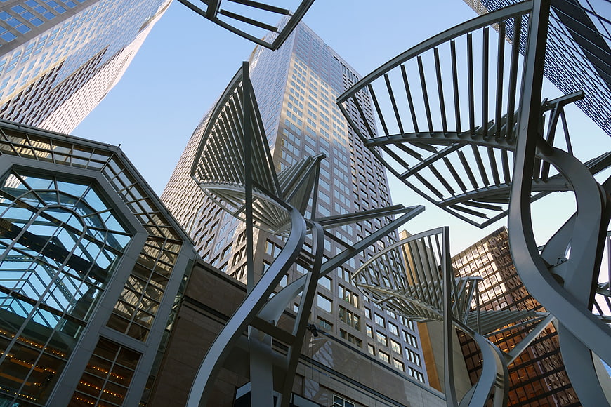Low angle view of modern city skyscrapers and abstract metal sculpture