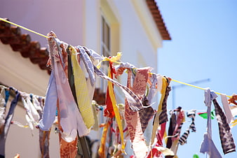 Colorful Fabric Strips Hanging on a Clothesline Against Blue Sky