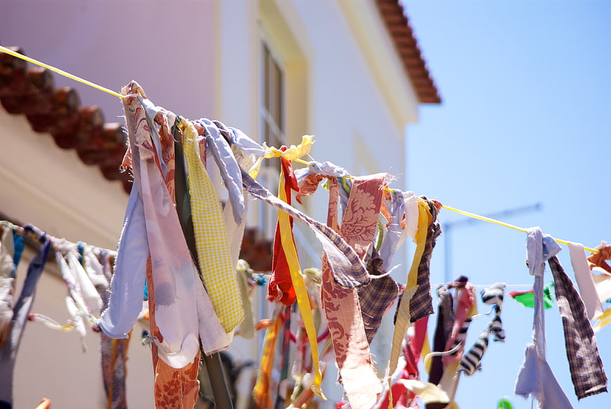 Colorful Fabric Strips Hanging on a Clothesline Against Blue Sky