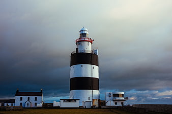 Dramatic Black and White Lighthouse Against Stormy Sky