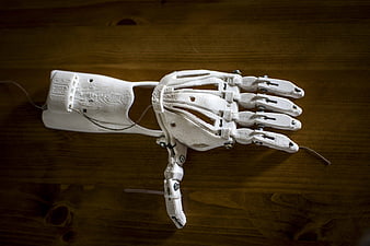 White 3D Printed Prosthetic Hand on Wooden Table