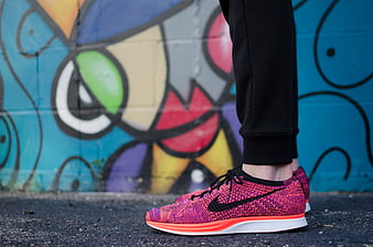Colorful Nike Running Shoes Against Vibrant Graffiti Wall
