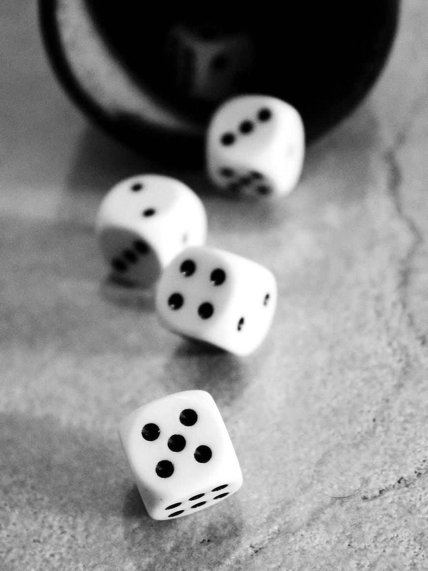 Black and white close-up of scattered dice on a textured surface