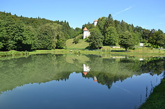 Serene Lake Reflection of Castle on Green Hillside