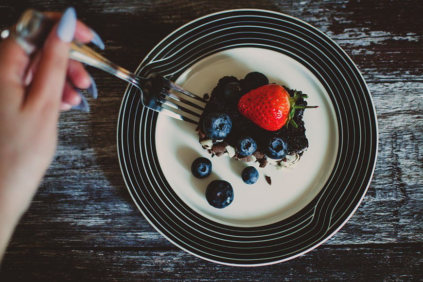 Overhead view of chocolate cake with berries on striped plate
