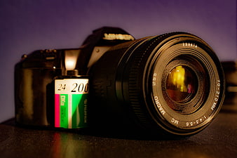 Vintage DSLR Camera with Film Roll on Dark Surface