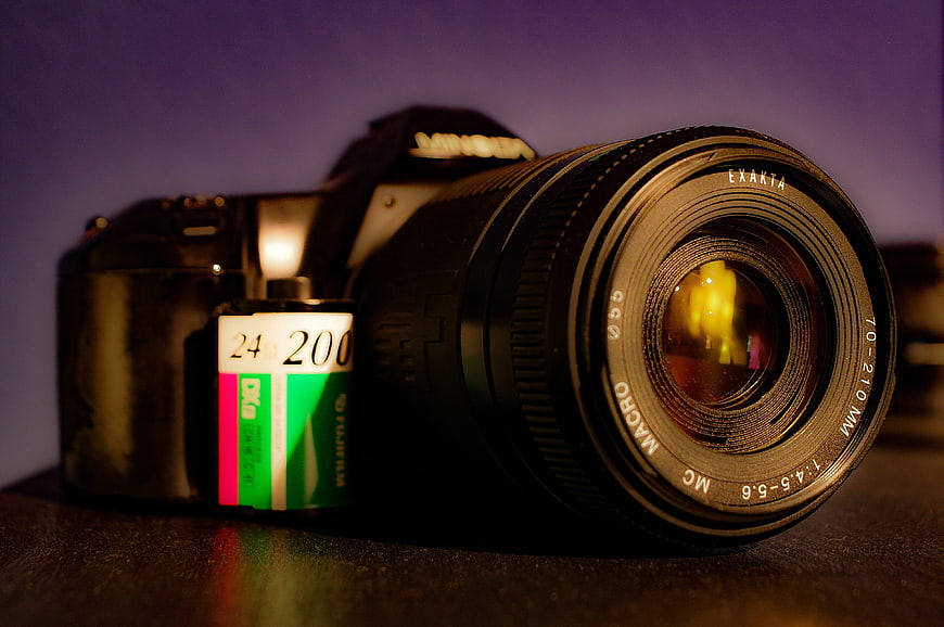 Vintage DSLR Camera with Film Roll on Dark Surface