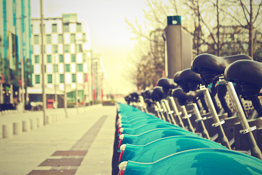 Row of teal rental bicycles in modern urban city street