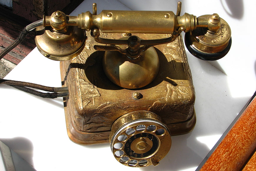 Antique Brass Candlestick Telephone on White Surface