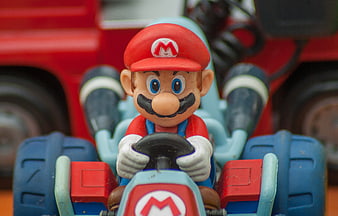 Close-up of vintage Mario toy figure in blue go-kart