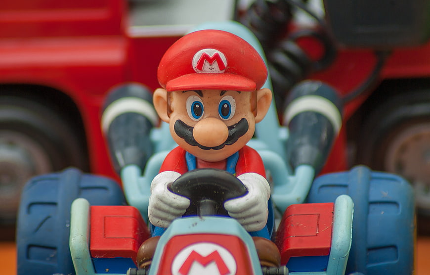 Close-up of vintage Mario toy figure in blue go-kart