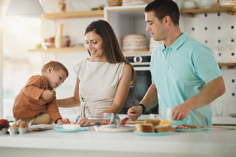 Happy family preparing breakfast together in modern kitchen