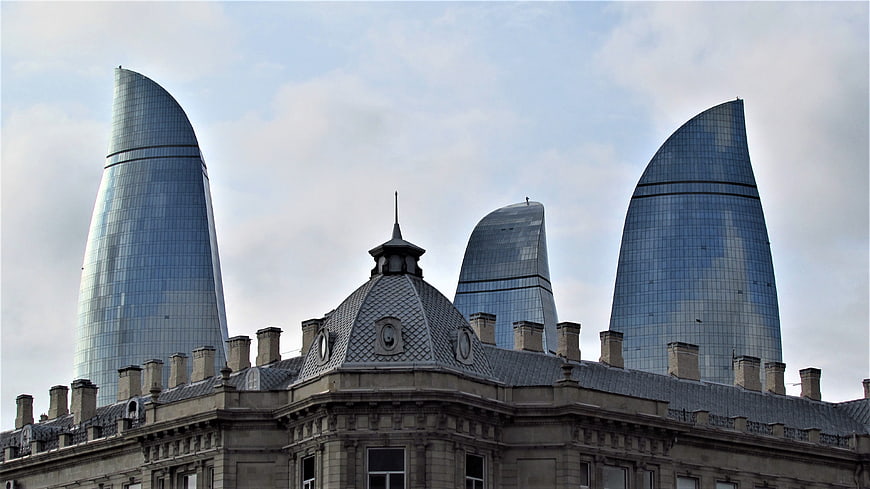 Flame Towers Baku skyline behind historic building roof