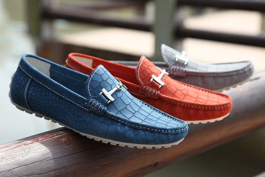 Blue, Red, and Gray Leather Horsebit Loafers on Wooden Railing