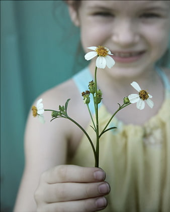 Girl holding white wildflowers with blurred smiling face