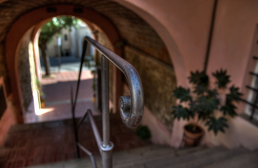 Close-up of ornate iron stair railing in Tuscan archway