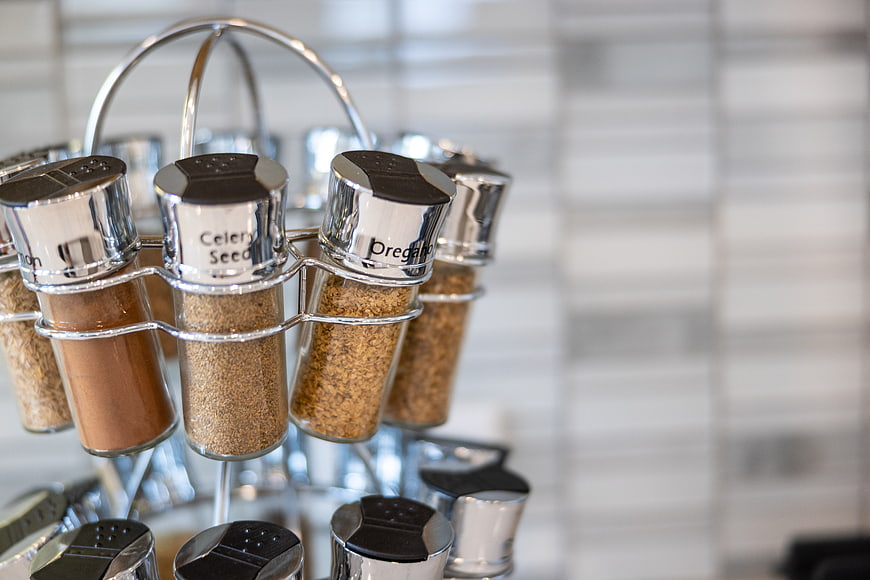 Close-up of spice rack with labeled seasoning jars in kitchen
