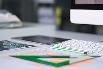Modern office desk with keyboard, tablet, and design tools