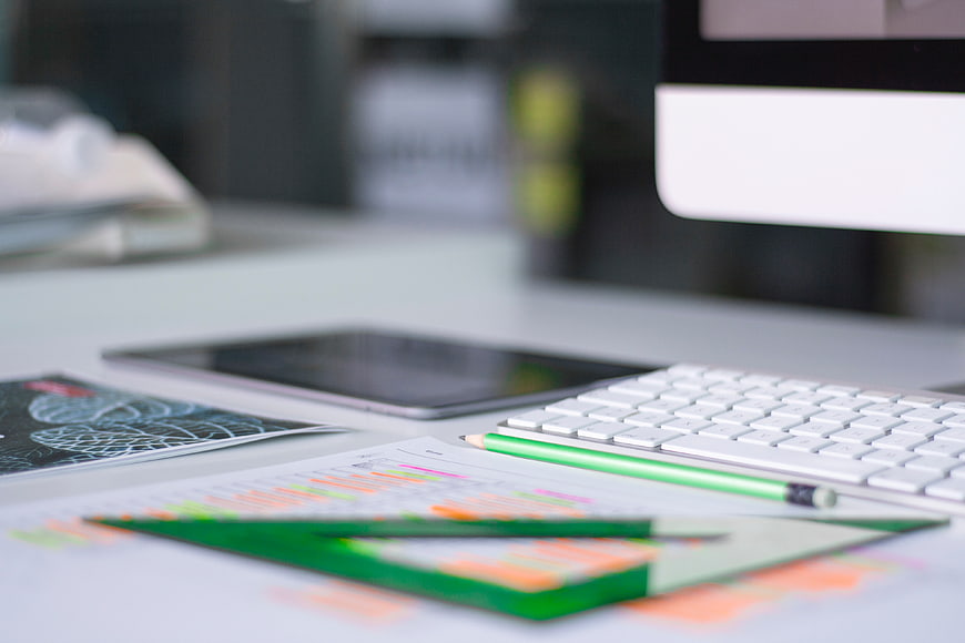 Modern office desk with keyboard, tablet, and design tools