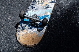 Worn Skateboard Deck on Asphalt Pavement