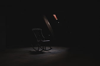 Dark moody rocking chair in dim attic room