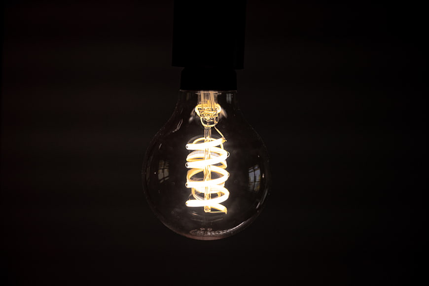 Illuminated Vintage Light Bulb on Dark Background