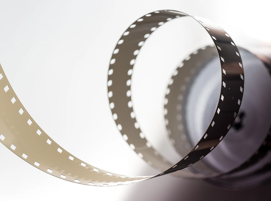 Curved black camera film strip on white background