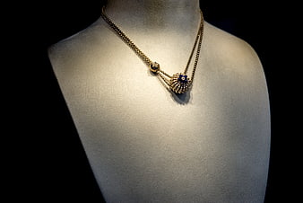 Luxurious Gold Necklace with Blue Gemstone on Display