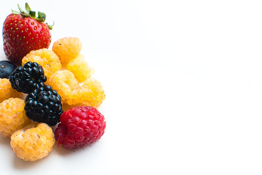 Fresh mixed berries on white background with copyspace