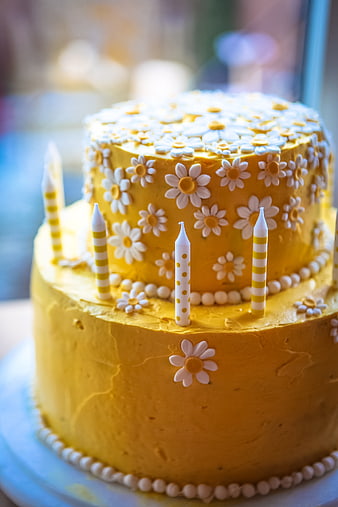 Two-Tier Yellow Birthday Cake With White Daisy Decorations And Candles