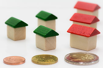 Wooden House Models and Euro Coins on White Background
