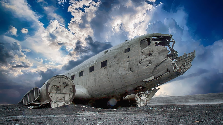 Aircraft Wreckage On Gravel Runway Under Dramatic Stormy Sky