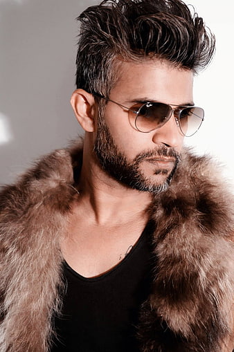 Handsome man with beard wearing sunglasses and fur coat