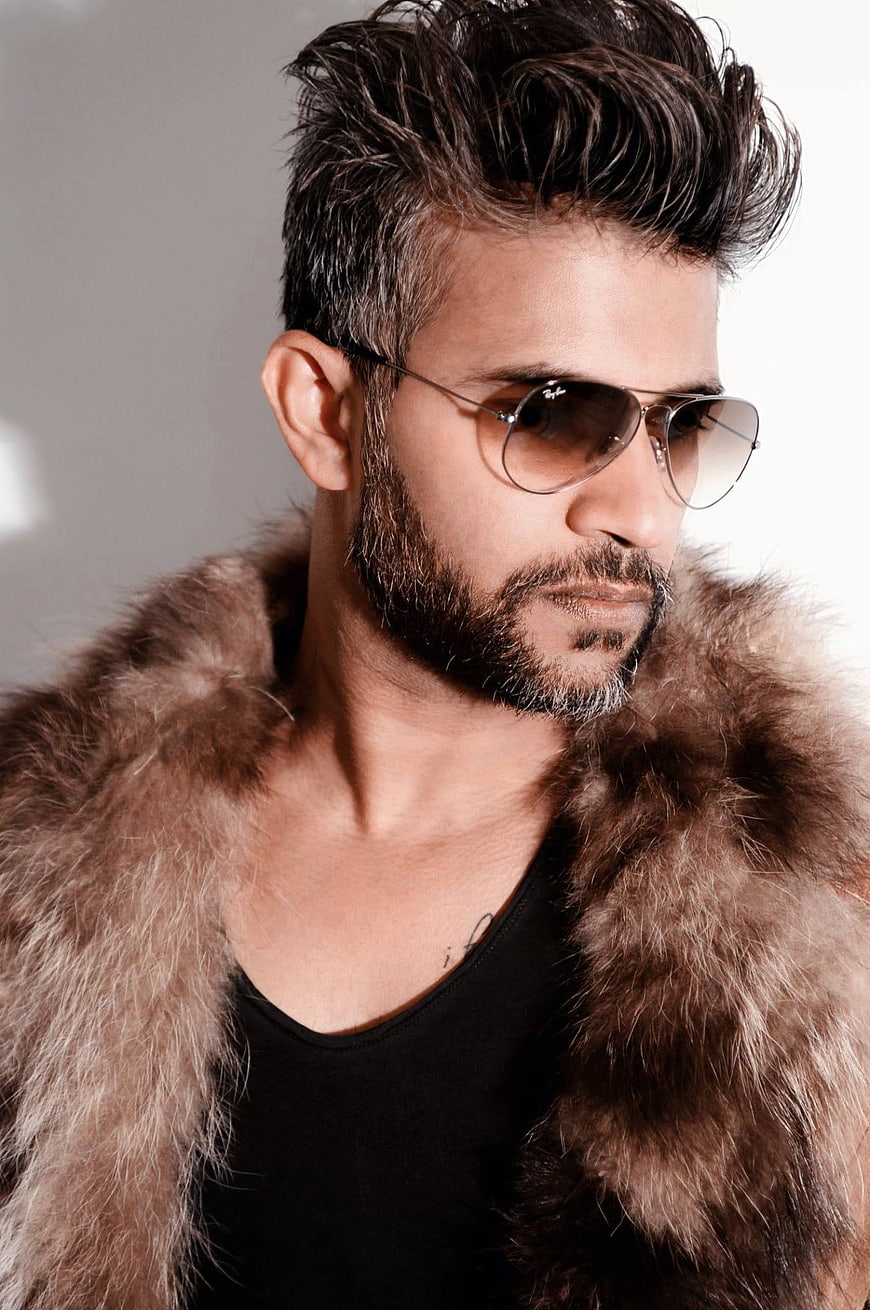 Handsome man with beard wearing sunglasses and fur coat