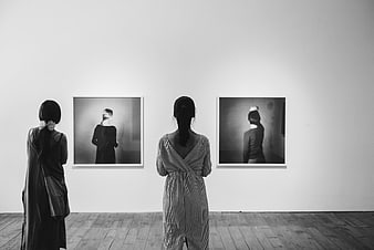 Two women viewing black and white art in gallery