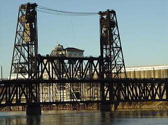 Industrial steel lift bridge over river with factory background