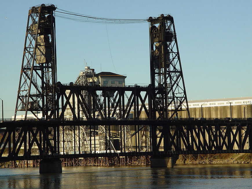 Industrial steel lift bridge over river with factory background
