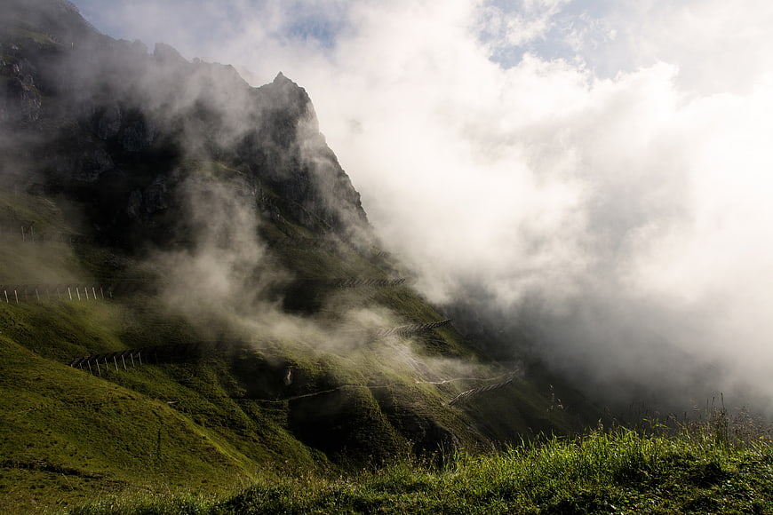 Misty green mountain landscape with fog and clouds