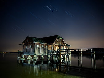 Wooden Stilt House with Star Trails at Night