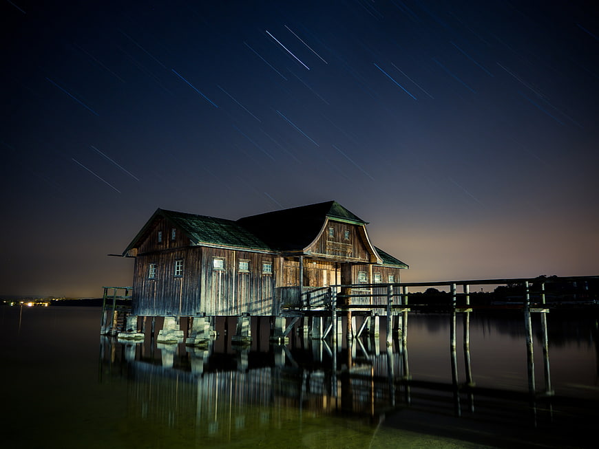 Wooden Stilt House with Star Trails at Night