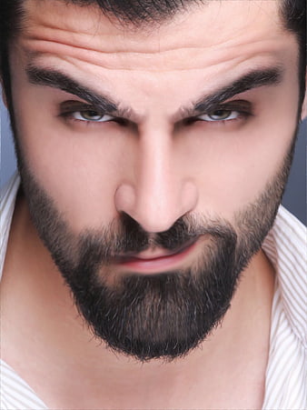 Close-up portrait of handsome bearded man with intense smirk