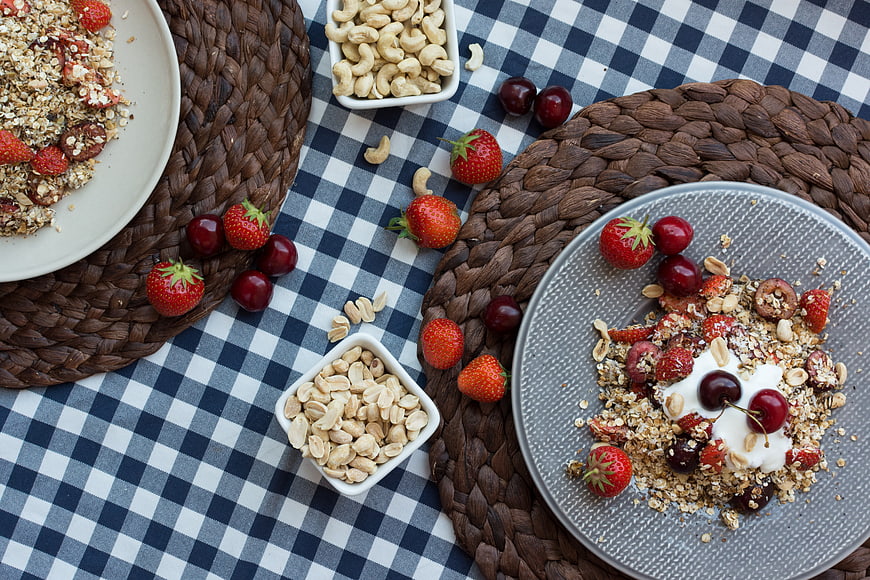 Top view of healthy granola breakfast with fresh strawberries and cherries