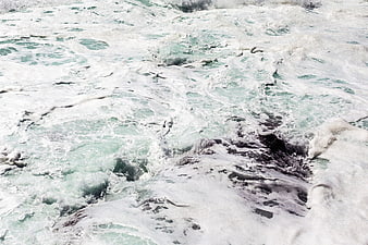 Turbulent turquoise ocean waves crashing over rocks
