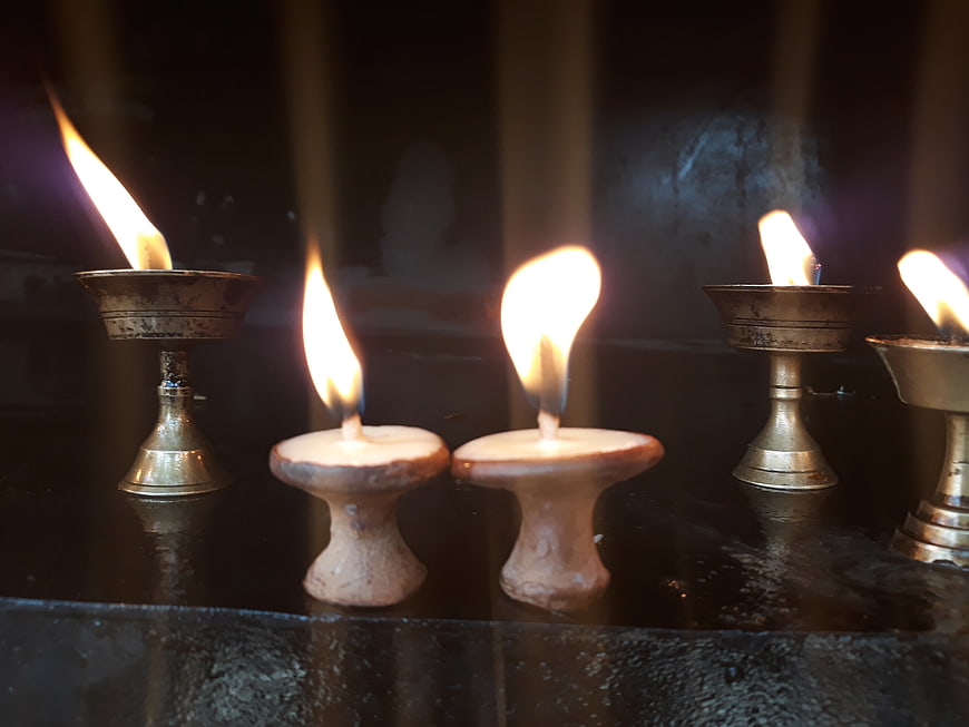 Traditional Nepali oil lamps and candles burning in a temple