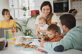 Happy family having breakfast and drawing together at kitchen table